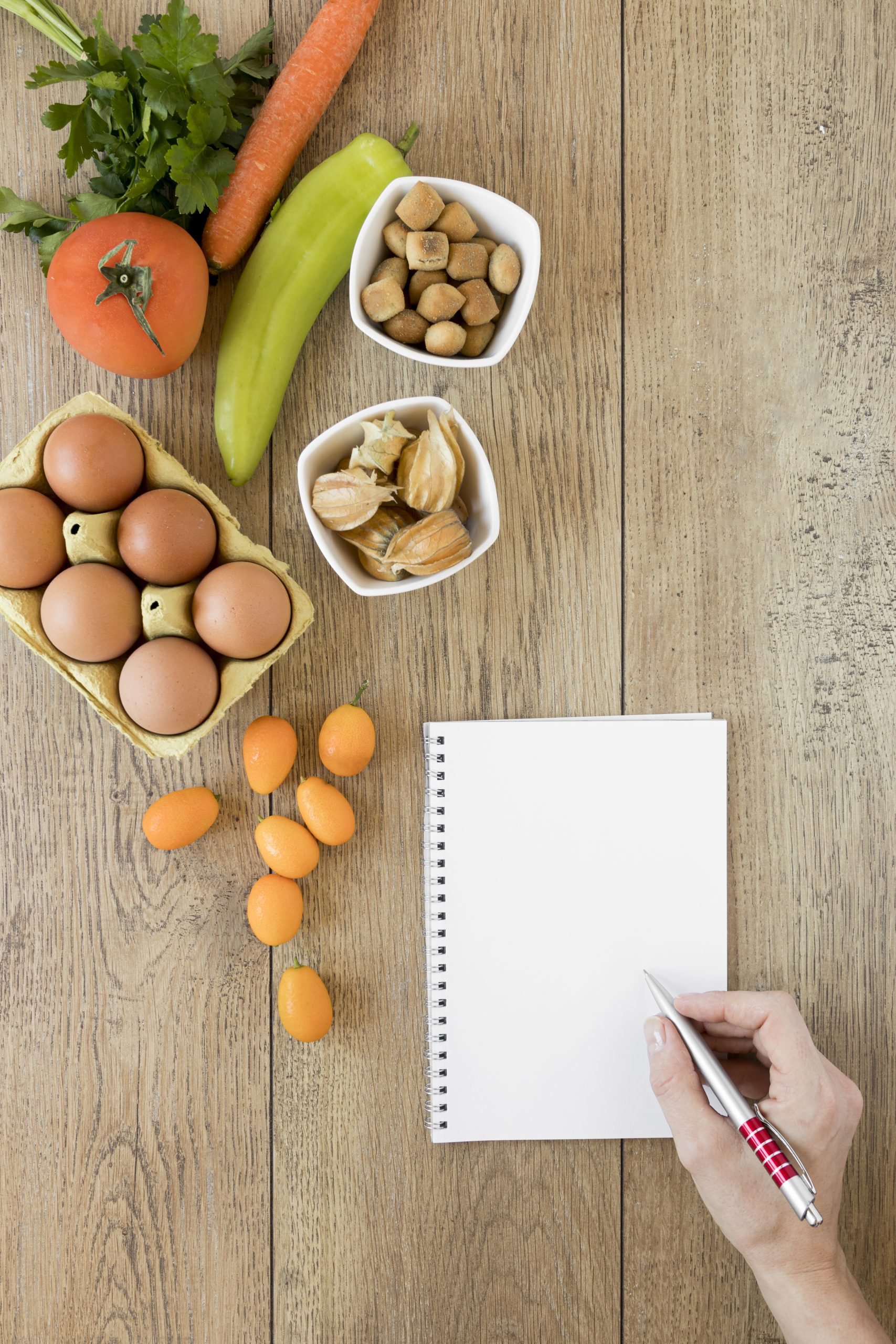 Healthy meal planning with fresh foods and notebook.