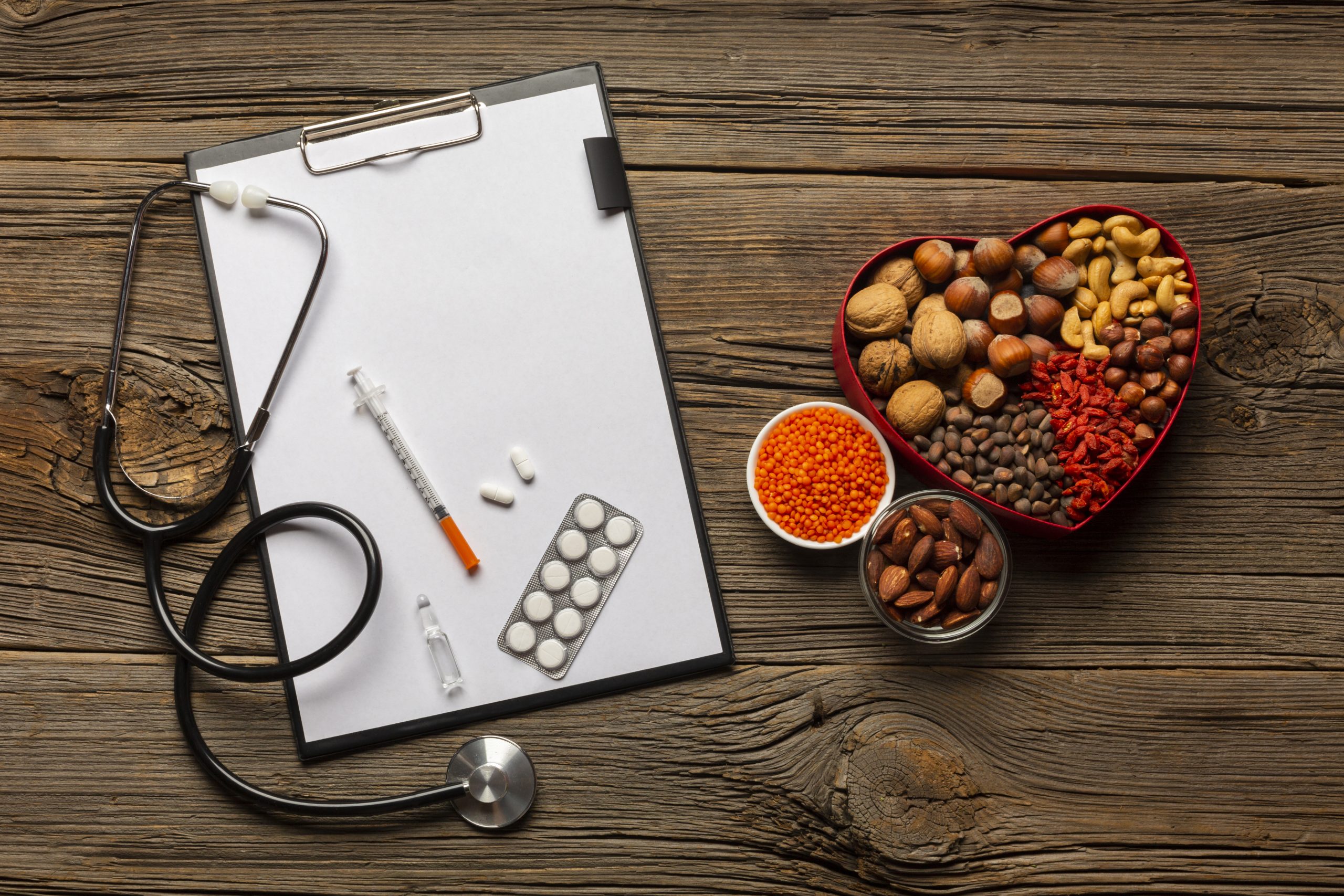Healthy lifestyle concept with stethoscope, clipboard, medicines, and heart-shaped bowl of nuts and seeds on wooden table.