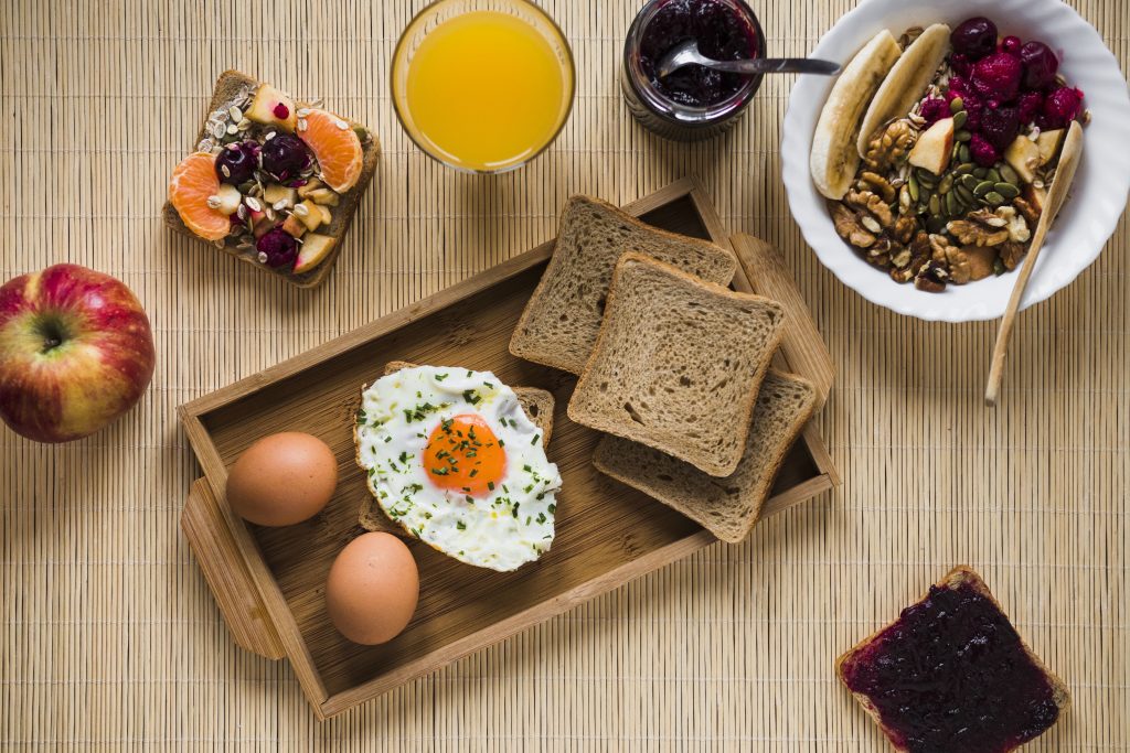 Healthy breakfast for women with eggs fruits whole grain bread and balanced nutrition.